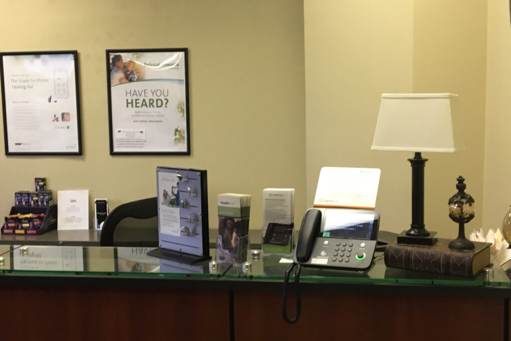 front desk at Help U Hear in Blue Ash with phone and various brochures