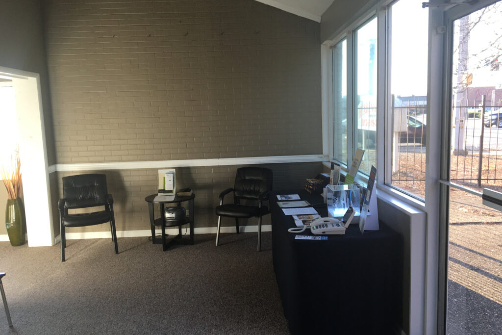 waiting area with two chairs and informational pamphlets on a table along one wall