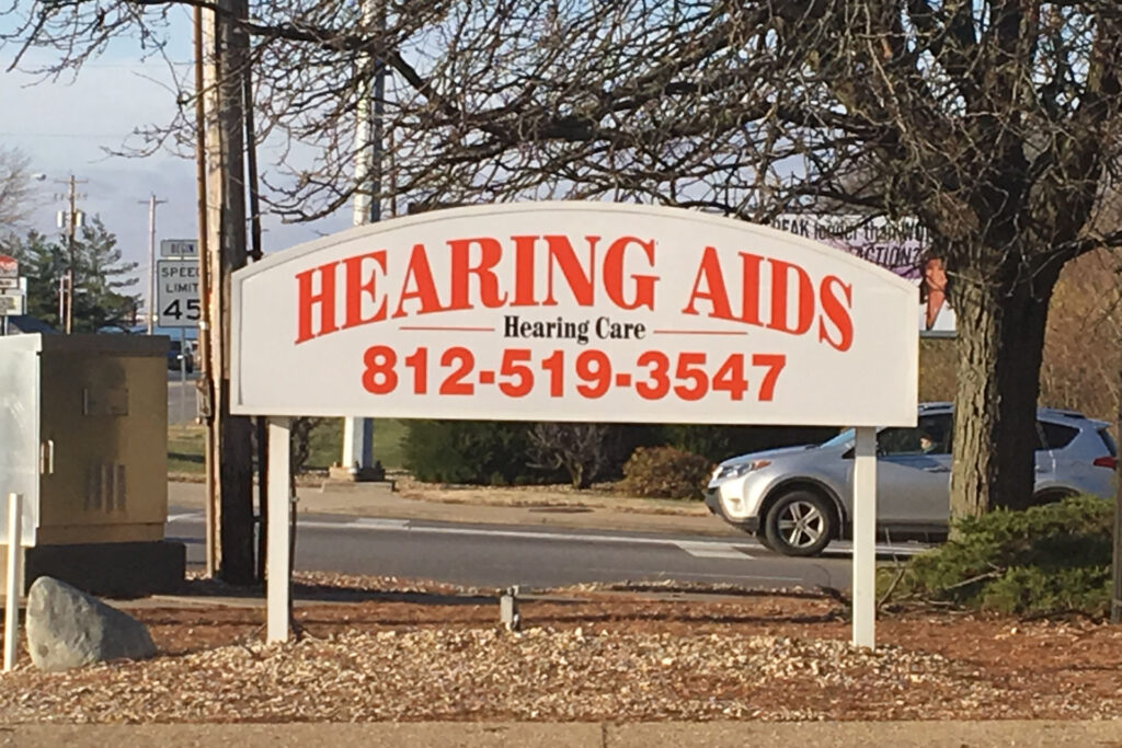sign outside Help U Hear that reads, "Hearing Aids - Hearing Care" with phone number, "812-519-3547"